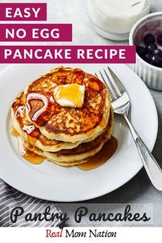 pancakes on a plate with syrup and blueberries next to milk in a glass container