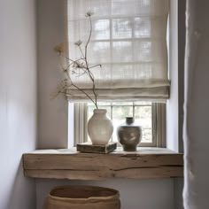 two vases sitting on a window sill next to a book