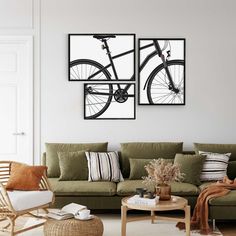 a living room with green couches and pictures on the wall above them in black frames