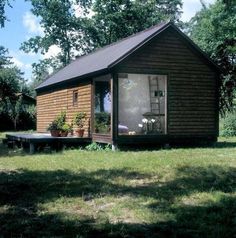 a small wooden cabin sitting on top of a lush green field