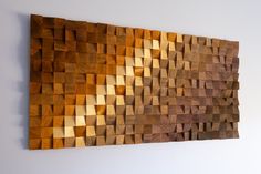 a wooden wall hanging on the side of a white wall with wood squares in it