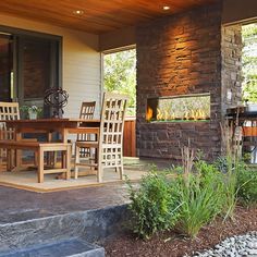 an outdoor dining table and chairs on a patio with fire place in the back ground