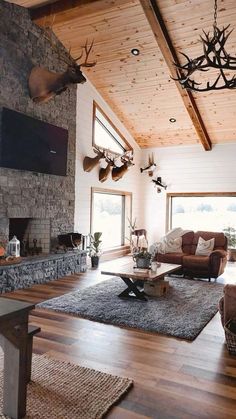 a living room filled with furniture and a fire place next to a stone faced wall