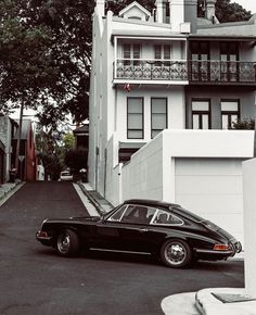 a black car is parked in front of some white buildings