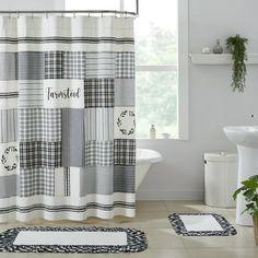 a bathroom with a shower curtain and rugs on the floor