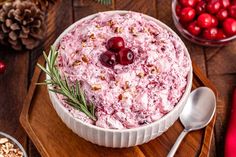 a bowl filled with cranberry salad on top of a wooden cutting board next to other dishes