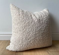 a white pillow sitting on top of a wooden floor