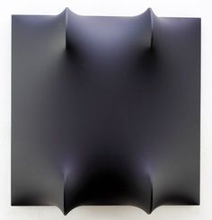 a black square shaped object on a white wall