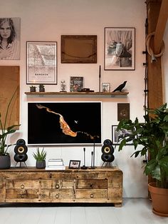 a living room filled with furniture and lots of pictures on the wall above it's entertainment center