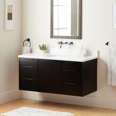 a bathroom with a sink, mirror and rug on the floor in front of it