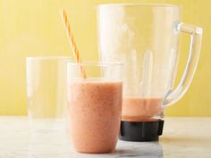 two blenders sitting next to each other on top of a marble counter with straws in them