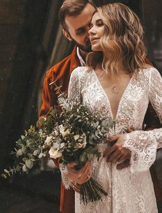 a man and woman standing next to each other holding flowers