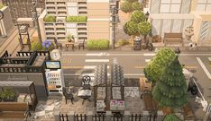 an aerial view of a city street with buildings and trees in the foregrounds