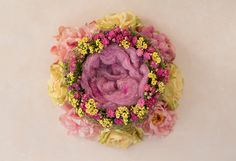 an overhead view of a flower arrangement with pink and yellow flowers in the center on a white surface