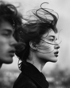 two people with their hair blowing in the wind