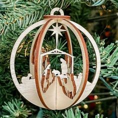 an ornament hanging from a christmas tree with the nativity scene in it