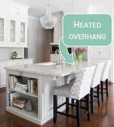 a kitchen with white cabinets and an island that has chairs on it in front of the counter