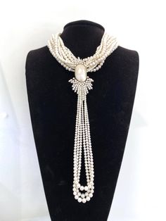 This one-of-a-kind dream necklace is created with multiple strands of freshwater pearls. The centerpiece is a unique, antique brooch made with 14k yellow gold and Mobé cultured pearls. This necklace is about 18" long, and the brooch measures at 3 1/2" x 2"