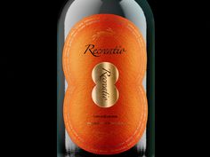 a bottle of red wine with an orange label on the top and bottom, in front of a black background