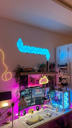 a computer desk with neon lights on the wall above it and a keyboard, mouse and monitor