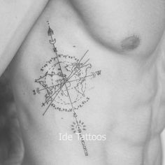 a black and white photo of a man's chest with a compass tattoo on it