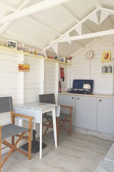 two chairs and a table in a small room with white paint on the walls,