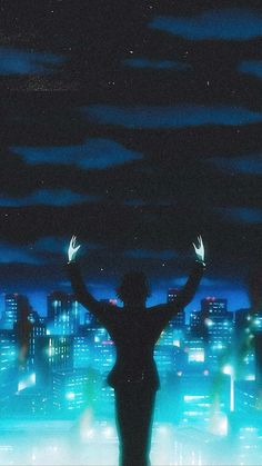 a person standing in front of a city at night with their arms up and hands raised