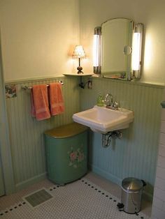 a white sink sitting next to a green trash can