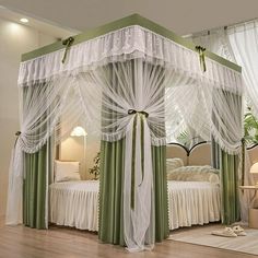 a canopy bed with sheer curtains on the top and bottom, sitting in a bedroom