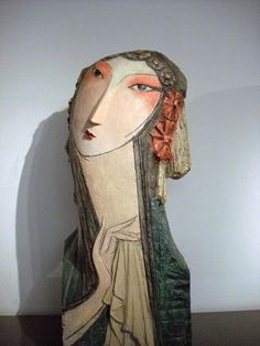 a ceramic sculpture of a woman's head with flowers in her hair