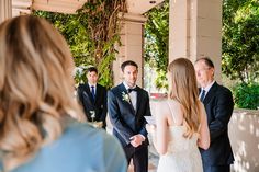 a bride and groom standing in front of their friends at the alter during a wedding ceremony