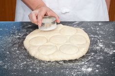 a person in an apron is kneading dough on a table