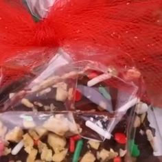 a bag filled with lots of candy and candies next to a red bow on top of a table