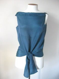 a mannequin wearing a blue top with a bow at the front and back