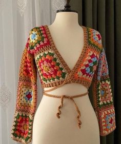 a white mannequin wearing a multicolored crochet top and belt