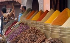 an outdoor market with lots of different colored spices