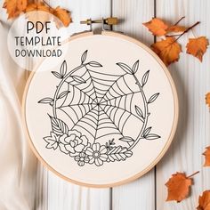 a cross stitch pattern with leaves and flowers on it, next to an embroidered spider web