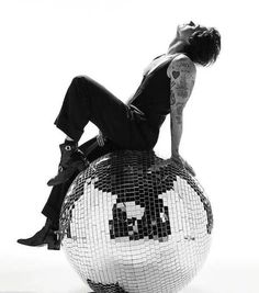 a woman sitting on top of a disco ball