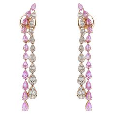 This stunning pair of long tassel earrings are designed in lustrous 14K yellow gold studded with 24 pear shaped pink sapphires in prong setting with another tassel studded with baguette and round brilliant cut diamonds in pear shaped designs. Total diamond weight: 1.20 carats. Diamond color H-I and clarity SI. Total pink sapphire weight: 3.03 carats. Impressive long tassels dangle earrings that dance with every step you make. Secured with pushback posts. Earring length: 2.4 inches. Total weight: Modern Bangle, Beautiful Stud Earrings, Long Tassel Earrings, Blue Sapphire Diamond, Long Drop Earrings, Heart Drop Earrings, Earring Crafts, Yellow Gold Earring, Diamond Drop Earrings