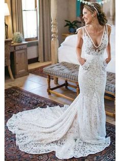 a woman in a wedding dress is standing near a bed