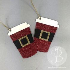 two red and white christmas stockings hanging from chains on a gray surface with gold trim