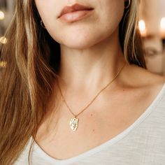 a close up of a person wearing a necklace with a dog tag on the front