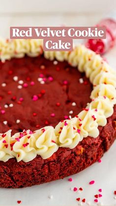 a red velvet cake with white frosting and sprinkles on the top