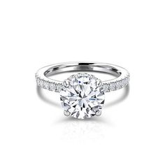 a white gold engagement ring with diamonds on the band and a round cut diamond in the center