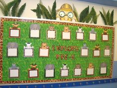 an animal themed bulletin board with pictures and animals on the front, surrounded by plants