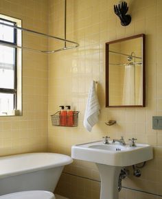 a white sink sitting under a bathroom mirror next to a bath tub