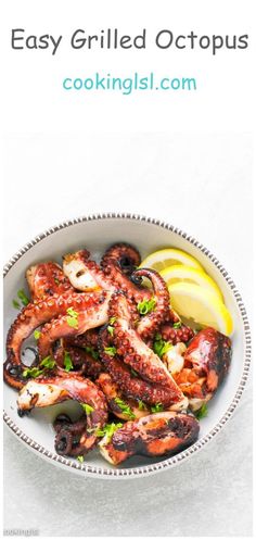 an octopus dish in a bowl with lemon wedges