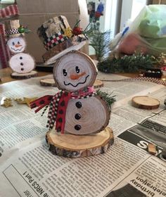 a snowman made out of wood sitting on top of a newspaper