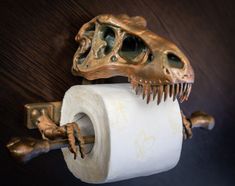 a close up of a toilet paper holder with a t - rex on it's side