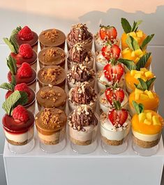 there are many small desserts on the white tray, each with different toppings